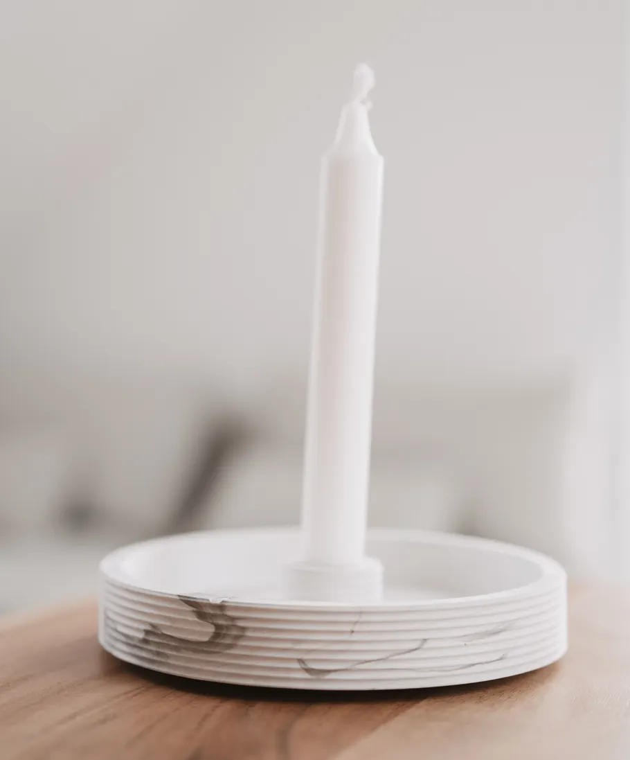 White candle in a marble holder indoors.