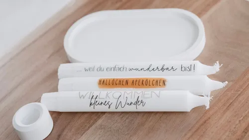 Three decorative candles on wooden surface.