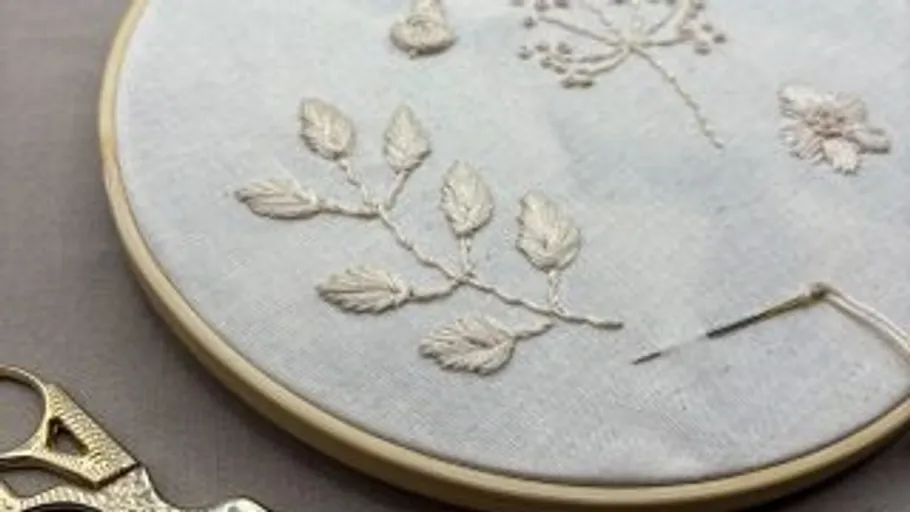 Embroidery hoop with floral designs on fabric.