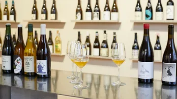 Wine bottles and glasses on a bar counter.