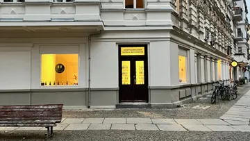 Corner wine store with lit window displays.