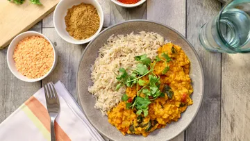 Linsencurry und Reis auf einem Teller.