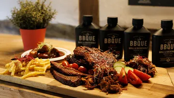 Barbecue platter with meats on wooden table.