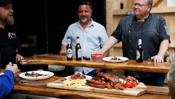 People enjoying barbeque food with drinks.