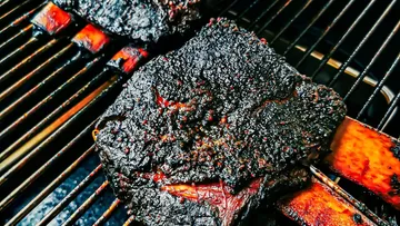 Barbecued beef ribs on a grill.