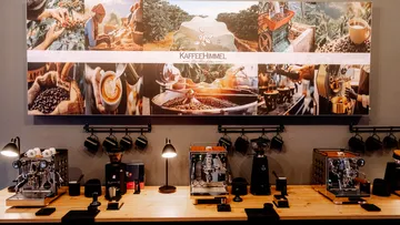 Coffee machines on wooden counter below collage.