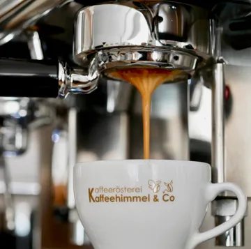 Espresso pouring into branded cup from machine.