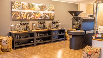 Coffee roaster and machines in cozy cafe.