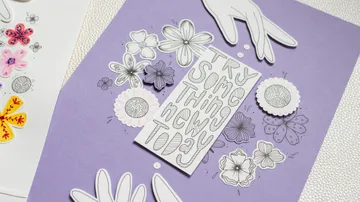Paper flowers and message on purple paper.