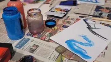 Art supplies and painting on newspaper.