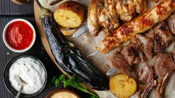 Gegrilltes Fleisch und Gemüse mit Dipsaucen.