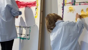Two people painting on large canvases.