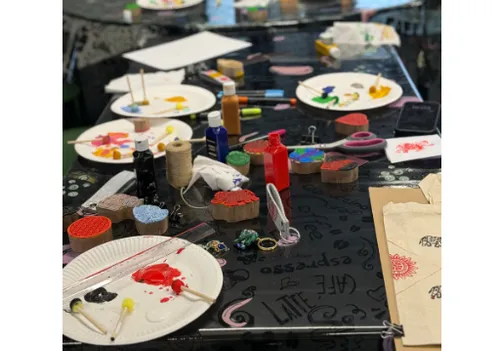 Bastelmaterialien und Farbe auf einem Tisch verstreut.