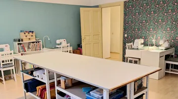 Spacious sewing room with tables and machines.