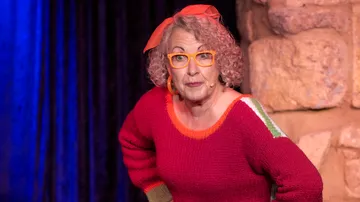 Woman in red sweater on stage.