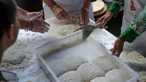 Hände bereiten Teig auf einem Tisch vor.