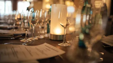 Wine glasses on a restaurant table setting.