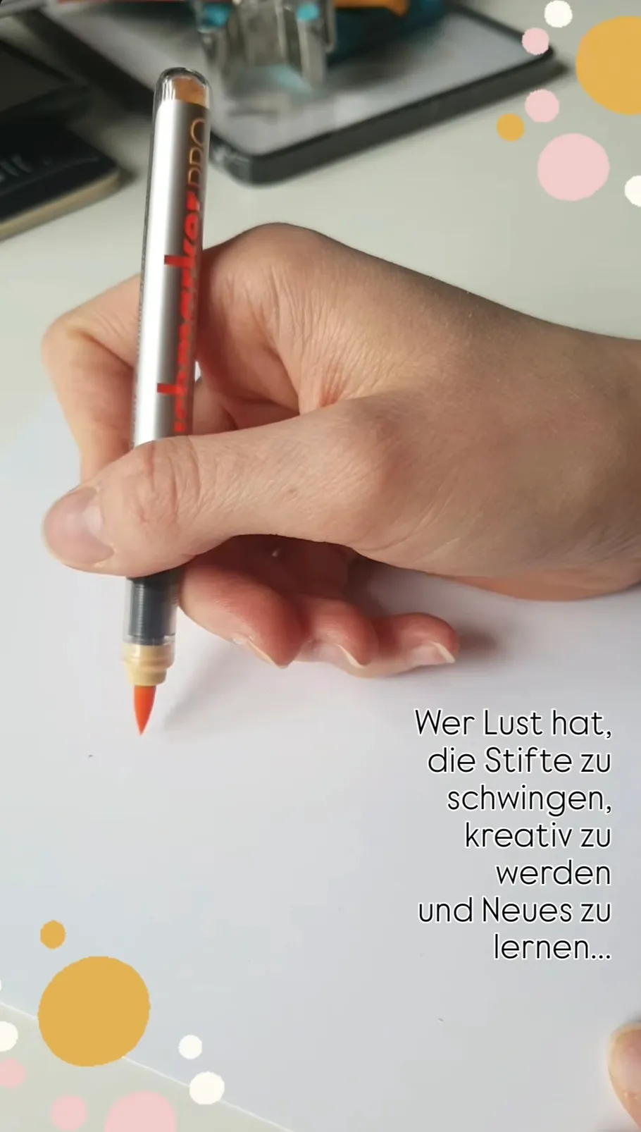 Hand hält roten Marker auf weißem Papier.