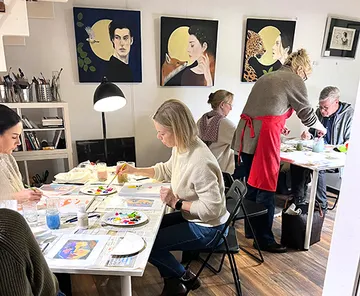 People painting in an art studio setting.