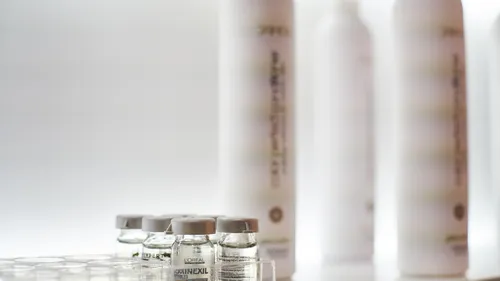 Small bottles and tall containers on a shelf.