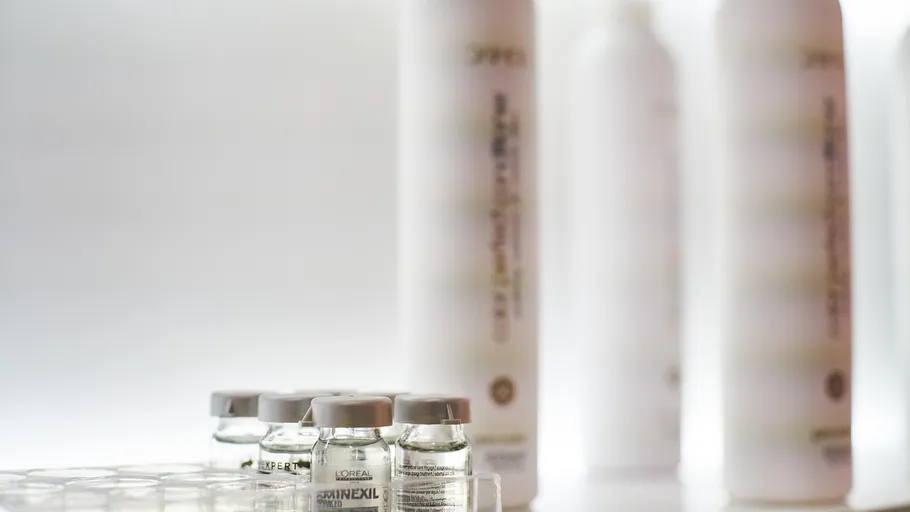 Small bottles and tall containers on a shelf.
