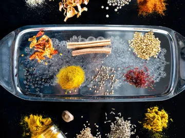 Spices are arranged on a tray to prepare ingredients.