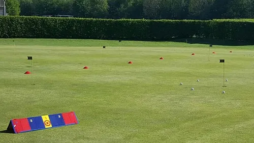 Golftrainingsbereich mit Fahnen und Kegeln.