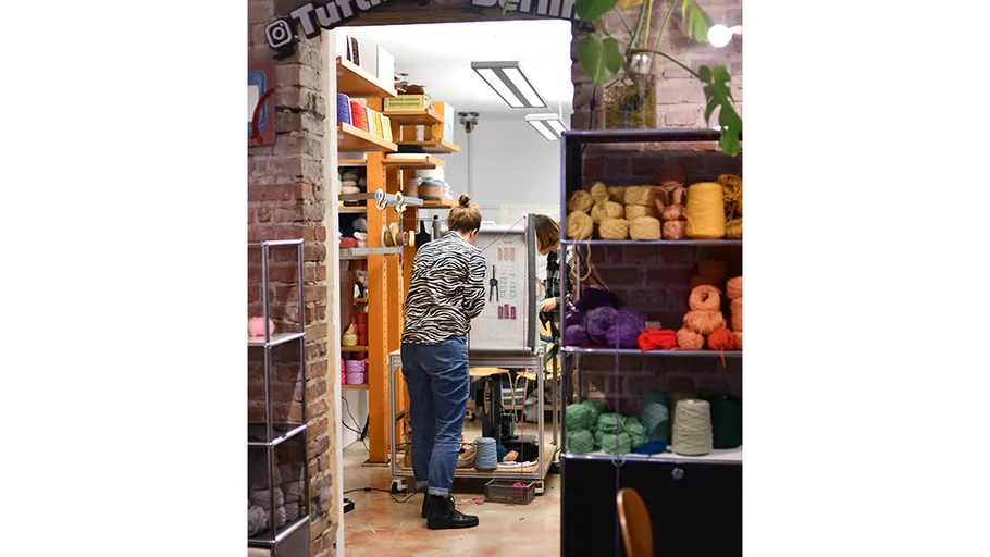 Person arbeitet in einem Wollgeschäftsraum.