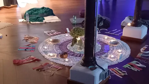 Dekoratives Mandala mit Kerzen auf Holzboden.