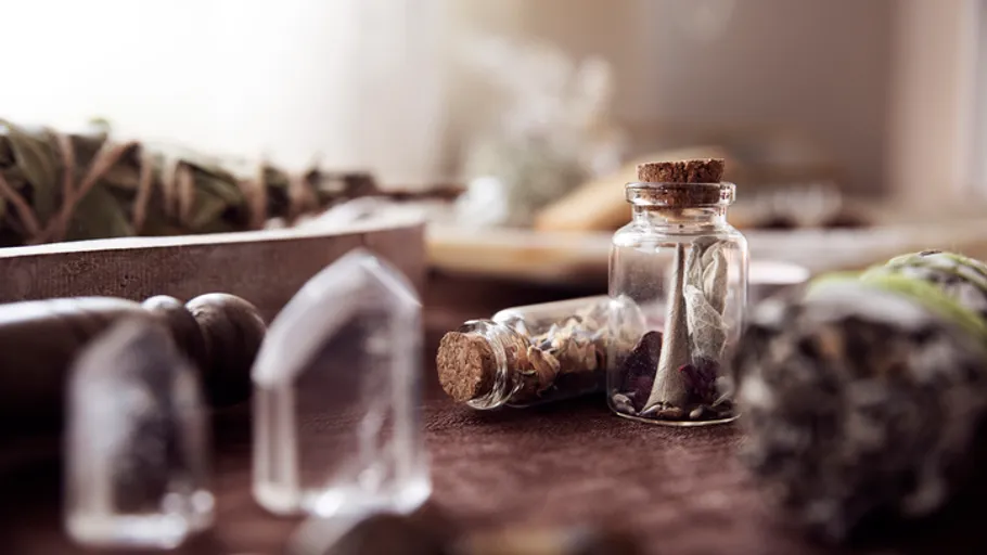 Glass jars with herbs on wooden table.