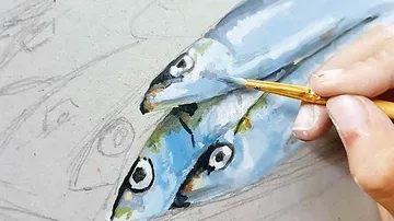 Hand painting fish on a canvas.