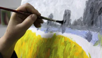 Hand painting landscape on canvas with brush.