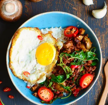 Fried egg and spicy beef on rice plate.