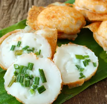Thai coconut pancakes with green onions on banana leaf.