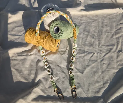 Braided lanyard with yarn spools on fabric.