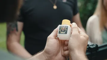 Person hält Flasche mit 'CHEMCHEME URSA'.