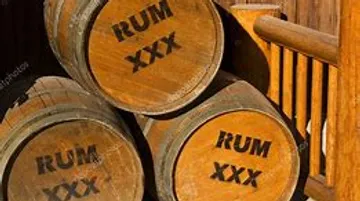 Drei Holzfässer mit Rum im Freien gestapelt.