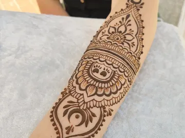 Henna-Muster auf einem Arm, dekorativ, auf hellem Untergrund.