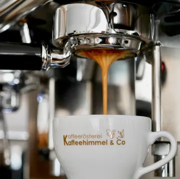 Espresso fließt in eine Marken-Tasse.