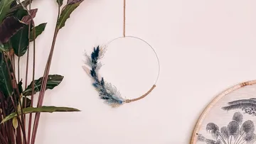 Decorative hoop with feathers on wall.