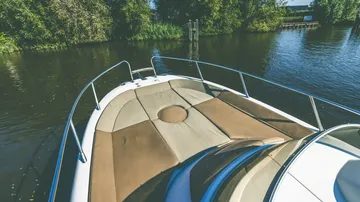 Boat with sunbed on calm river.