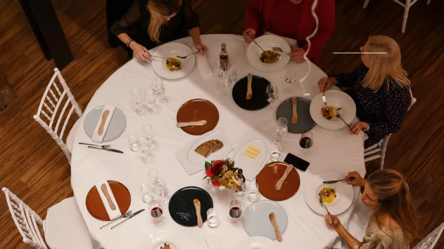 People dining at a round table indoors.