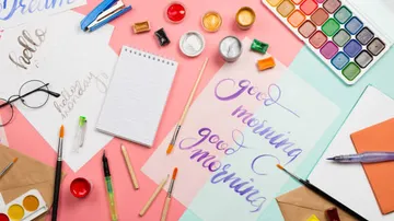Art supplies and handwritten notes on table.