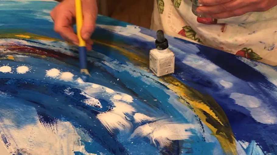 Person painting abstract art on canvas.
