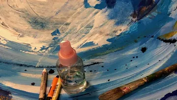 Art supplies on colorful painted surface.