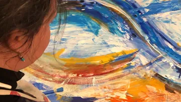 Person painting colorful abstract artwork.