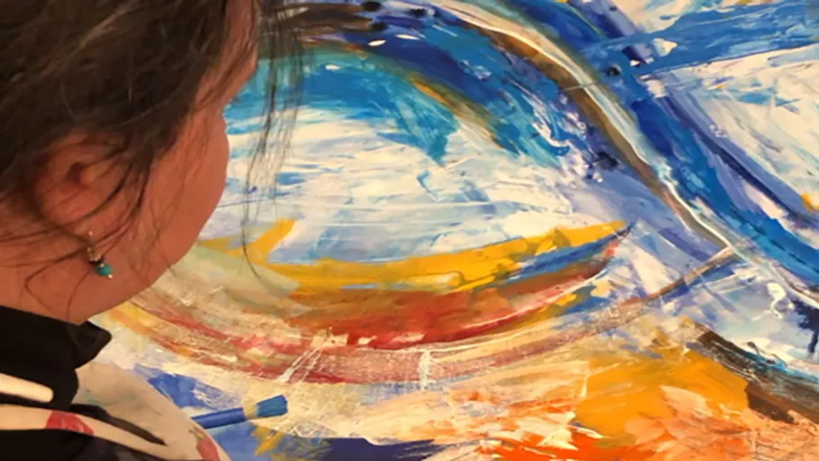 Person painting colorful abstract artwork.