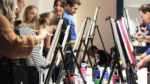 People painting on canvases in a studio.