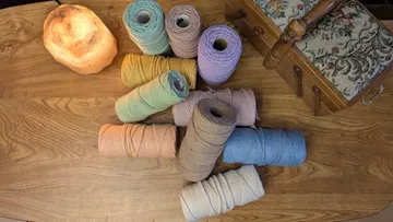Bunte Garnspulen auf einem Holztisch.