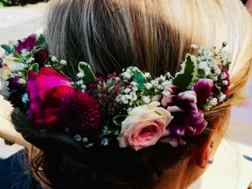 Blumenkranz auf dem Kopf einer Person, in natürlichem Licht.